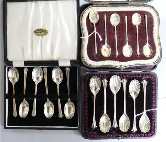 Three assorted cased sets of silver coffee spoons.